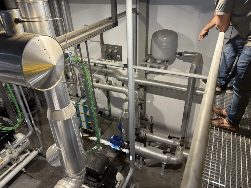 Sala de máquinas con conducto aislado, vaso de expansión y tubería de acero inoxidable