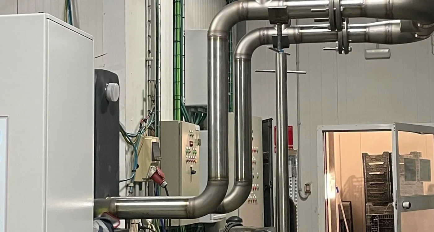 Tubería de acero inoxidable y cuadros de control en la sala de máquinas de una instalación frigorífica